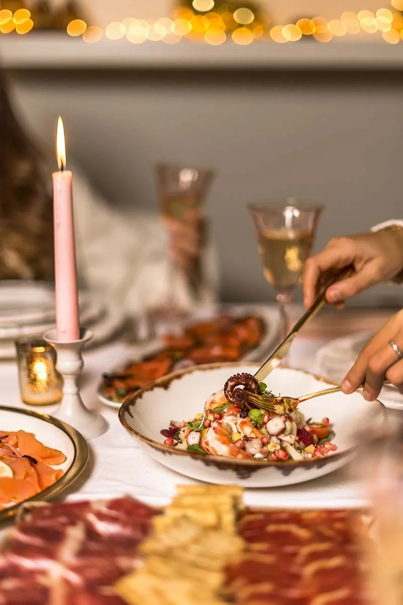 Mesa de Navidad con ensalada de marisco y pulpo, velas y ibéricos